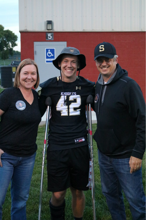  Isaak Wilson poses for a picture with his parents before walking down the field for senior night. 