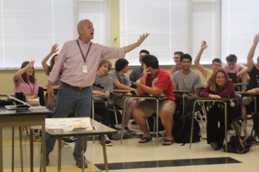 Timothy Tidball teaches his class with hands raised all around
