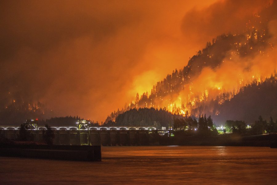 This Monday, Sept. 4, 2017, photo provided by KATU-TV shows a wildfire as seen from near Stevenson Wash., across the Columbia River, burning in the Columbia River Gorge above the Bonneville Dam near Cascade Locks, Ore. A lengthy stretch of highway Interstate 84 remains closed Tuesday, Sept. 5, as crews battle the growing wildfire that has also caused evacuations and sparked blazes across the Columbia River in Washington state. (Tristan Fortsch/KATU-TV via AP)