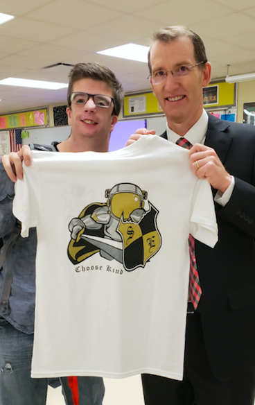 Kolton Ryba and Principal Toalson show off the Kindness Week Tshirts that are on sale for $5. The graphic on the back of the shirt depicts a Knight wearing an astronaut helmet and was inspired by the movie Wonder. Photo by: Michelle Stewart