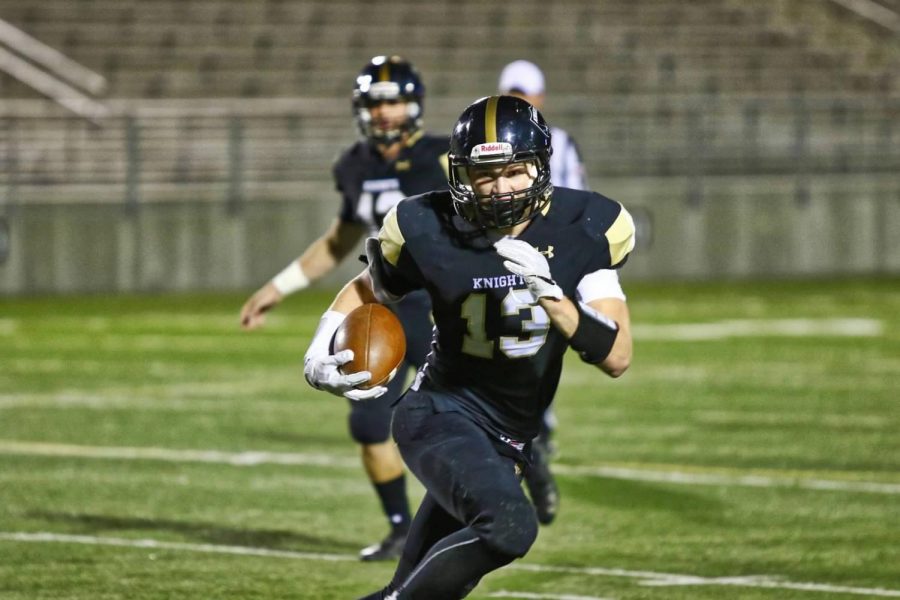 Gifford carries the ball while injured during the Pius X game, Oct. 4