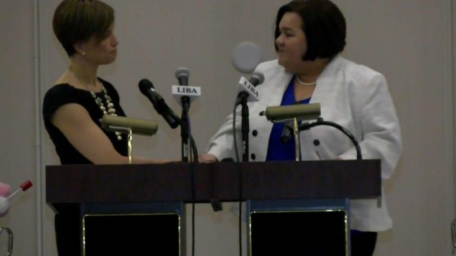 Mayoral candidates Leirion  Gaylor Baird (D) and Cyndi Lamm (R) shake hands at their first mayoral debate of 2019.