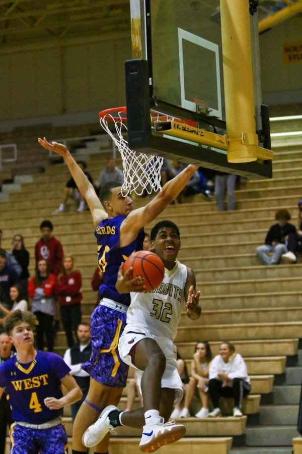 Ajantae Hogan (11) attempts a reverse layup under heavy pressure.