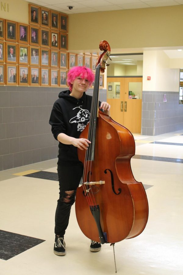 Tomasek poses with their bass of choice outside of the music hall.