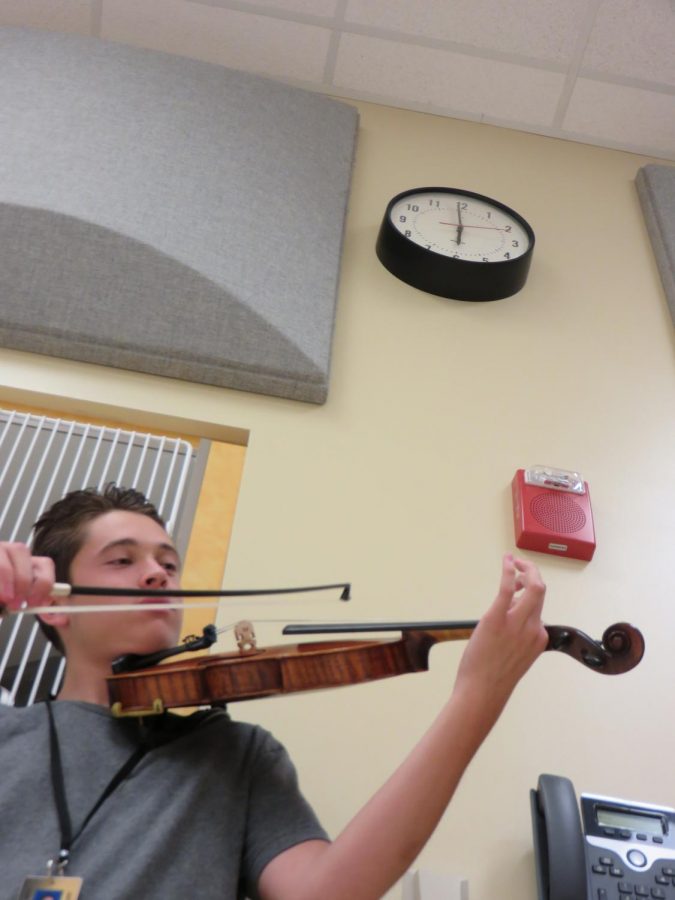 Senior Cyden Gonzales plays his violin down in the bounds of M-Hall