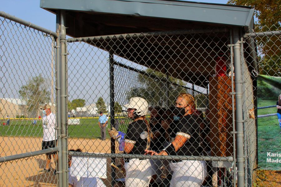 Teammates Rylan Ewoldt (12), and Alexis Hubbard (11), cheer on the Knights in the dugout.