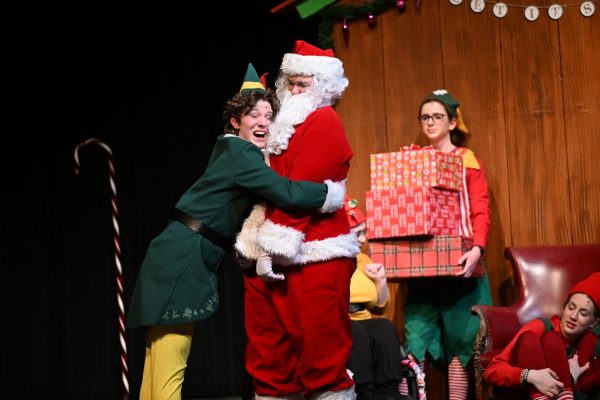 Buddy, played by Levi Baker, hugs Santa.