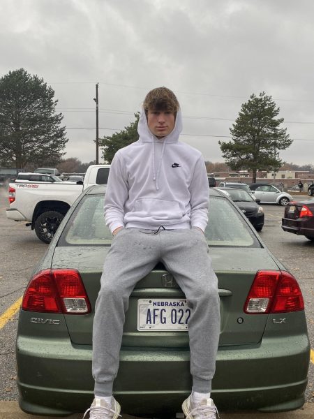 Jackson Bills sits on top of the trunk of his car