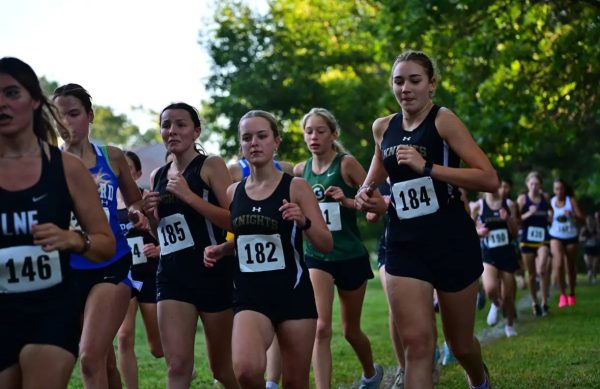 Drew Lohrman and Bea McKillip run in a Girls Junior Varsity Cross Country race.
Photo Credits: Jason Petersen