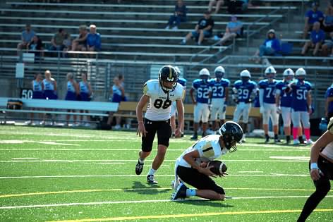 Sophomore Sam Baltensperger sets the hold for Jumior Cyrriac Jouberts field goal attempt against the Linocln East Spartans.
Photo Credit: Mike Johnson